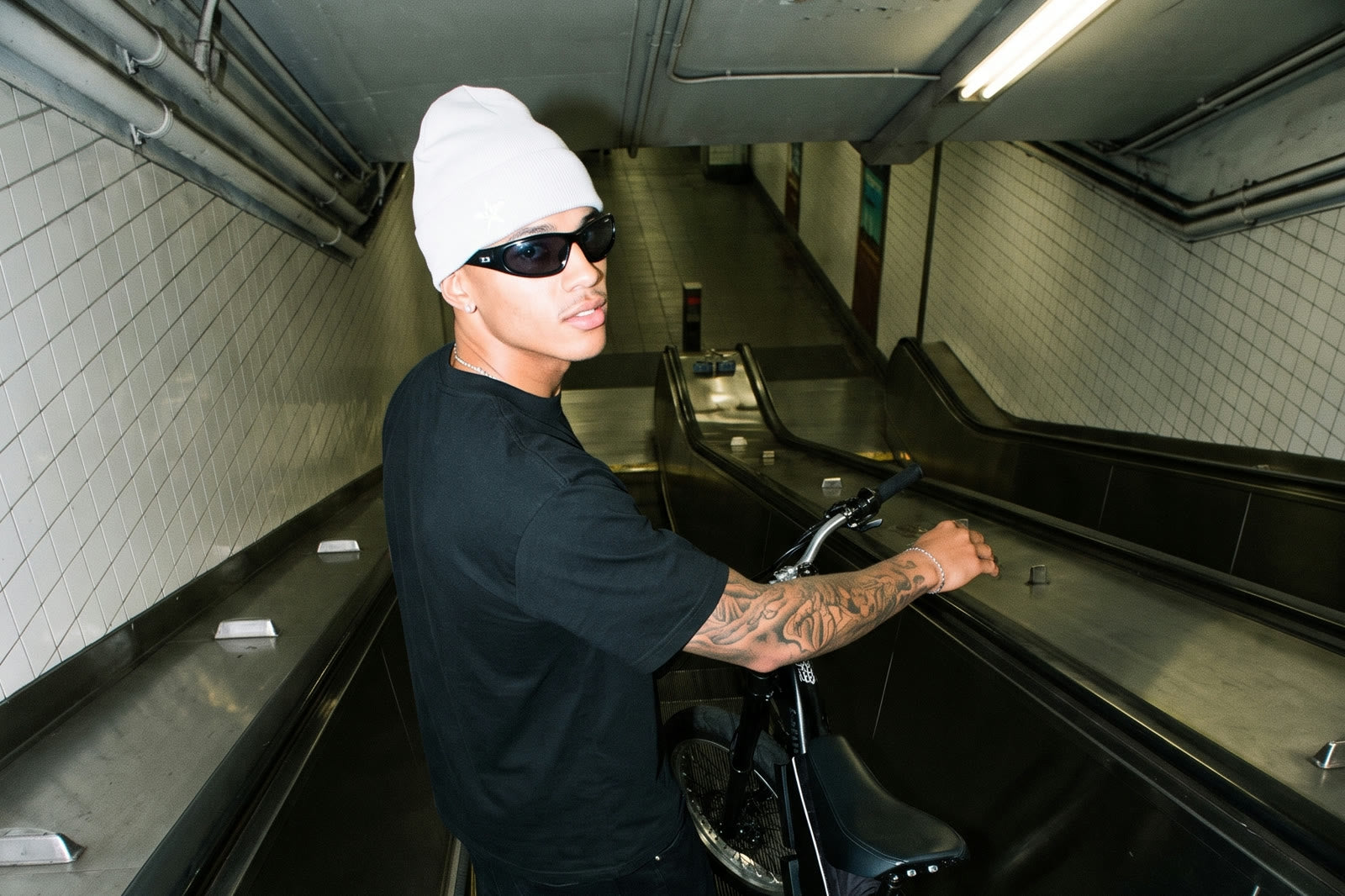 Rider with an F1 e-bike on a subway escalator